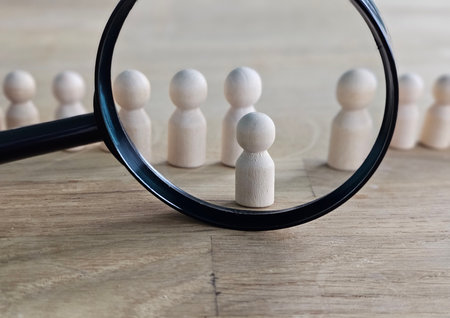 Recruitment and job search magnifying glass with wooden people concept for human resources and selecting the right peopleの写真素材