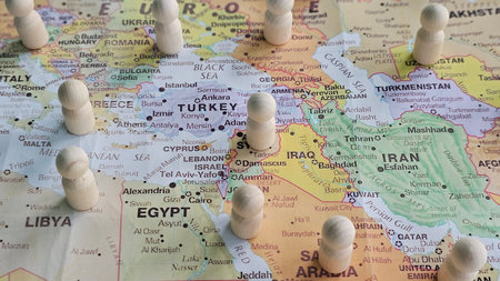 Exploring the Middle East with wooden figures on a detailed map showing countries and cities conceptの写真素材