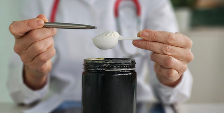 Healthcare professional prepares a supplement dose using a measuring spoon in a clinical setting