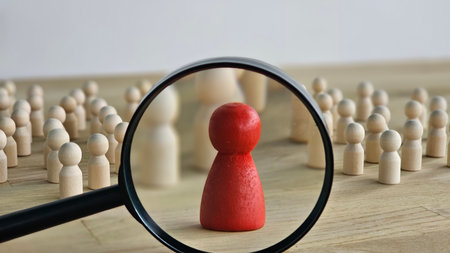 A magnifying glass and a red wooden figures with blur business man who search for someone who special person. Concept of Human resources management and recruitment.の写真素材