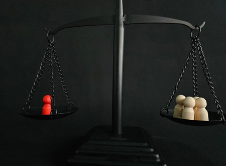 Balance of perspectives shown through scale with red figure opposed to multiple wooden figuresの写真素材