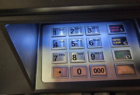 Close up of ATM keypad with illuminated buttons used for entering numbers and commands in banking transactionの写真素材