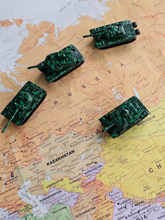 Toy tanks placed on a map showing parts of Russia and surrounding countries in eastern Europe and Asiaの写真素材