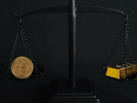 Balance between Bitcoin and gold on a scale in a dark setting highlighting financial valuesの写真素材