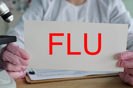 Scientist holding a sign that says flu in a laboratory setting during a research sessionの写真素材
