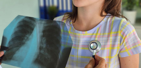 Pediatrician with stethoscope listening to lungs of coughing little girl during examination, professional orthopedic doctor checking teenager health conditionの写真素材