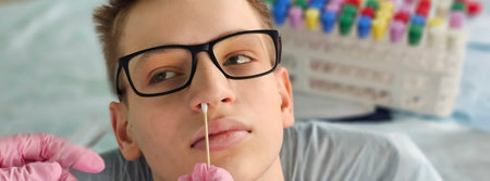 A virologist takes a cotton swab from a teenager's nose to analyze saliva, mucous membrane for DNA...