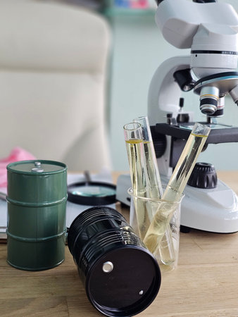 Workstation with microscope, glass test tubes, and equipment on wooden table during laboratory...