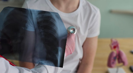 Doctor examines chest X-ray of patient during consultation in medical office