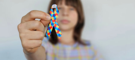 Teenager holding colorful ribbons raising awareness about autism. Girl for inclusion and...