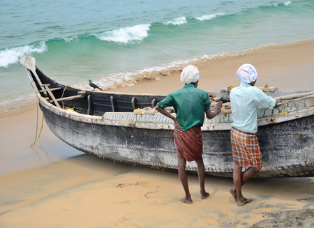 Fishermen near the boat on the beach of Kovalama India.のeditorial素材