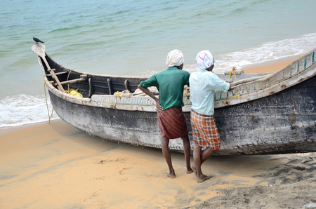 Fishermen near the boat on the beach of Kovalama India.のeditorial素材