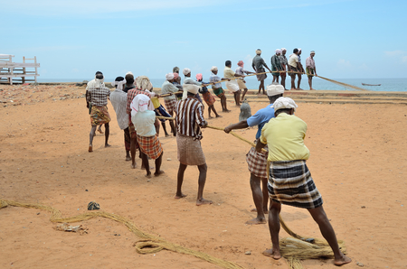 Traditional fishermen are pulling the seine fishing net from the sea in the beach of Kovalam.のeditorial素材