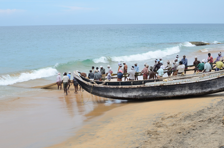 Traditional fishermen are pulling the seine fishing net from the sea in the beach of Kovalam.のeditorial素材