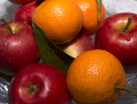 vase with apples and mandarin orangesの写真素材
