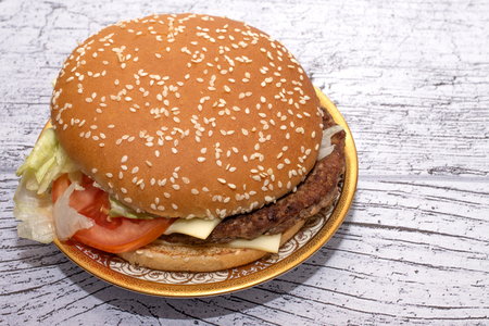burger with salad in a beautiful plate on a wooden tableの写真素材