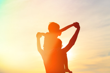 father and son having fun at sunsetの写真素材