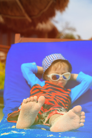 little boy relaxed on summer tropical beachの写真素材