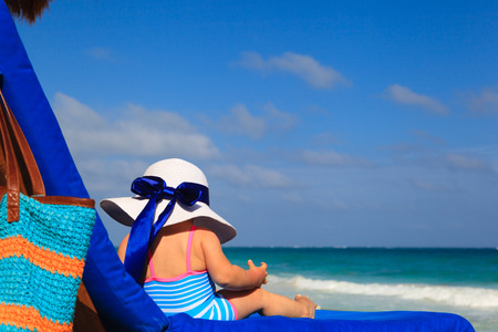 little girl in big hat on summer tropical beachの写真素材