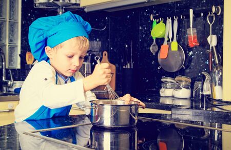 little boy enjoy cooking in kitchen interiorの写真素材