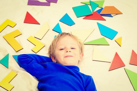 happy little boy with puzzle toys on white, early learningの写真素材