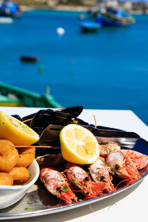 Seafood platter served in mediterranean restaurant against the seaの写真素材
