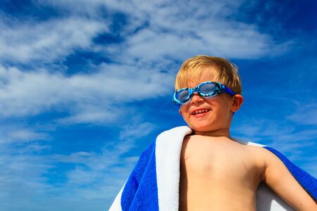 happy boy in swimming goggles on summer sea beachの写真素材
