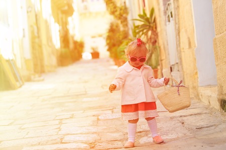cute little girl walking in the city of Europeの写真素材