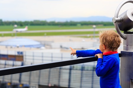 little boy looking at planes in the airport, kids travelの写真素材