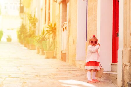cute little girl walking on the street of Malta, Europeの写真素材