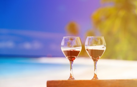 two wine glasses on sand tropical beachの写真素材