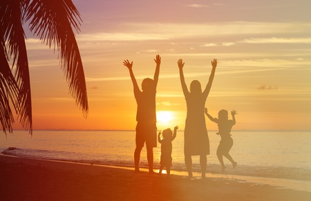 happy family with two kids having fun on sunset tropical beachの写真素材