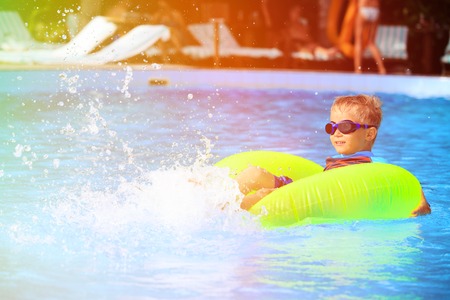 little boy in life ring having fun in the swimming poolの写真素材