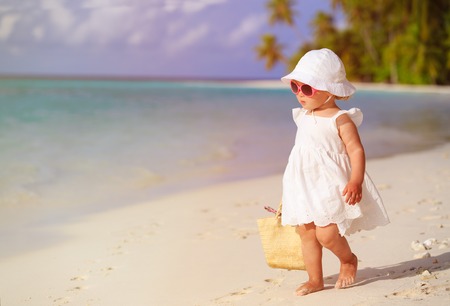 cute little girl walking on summer tropical beachの写真素材
