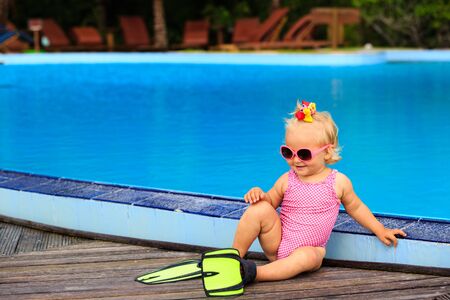 cute girl with flippers in swimming pool at tropical beachの写真素材