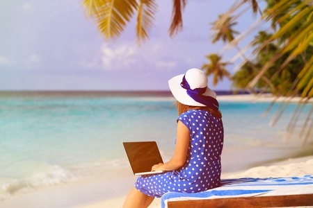 young woman with laptop on tropical beach vacationの写真素材