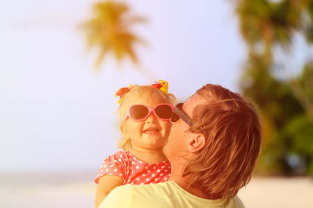 Happy father and cute little daughter at beach, family careの写真素材