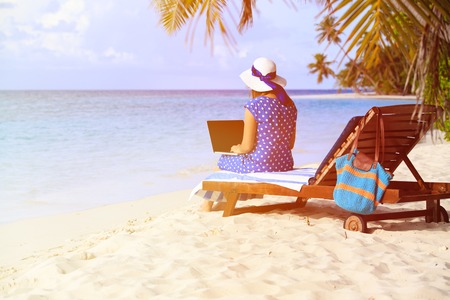 young woman working on laptop at tropical vacationの写真素材