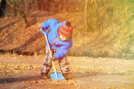 little boy digging in autumn park, autumn kids activities