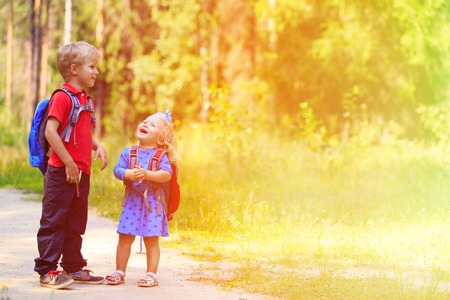 happy little boy and girl with backpacks in summer, kids go to schoolの写真素材