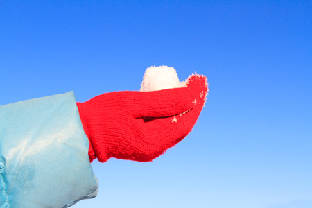 love winter concept - hand in gloves holding snowの写真素材