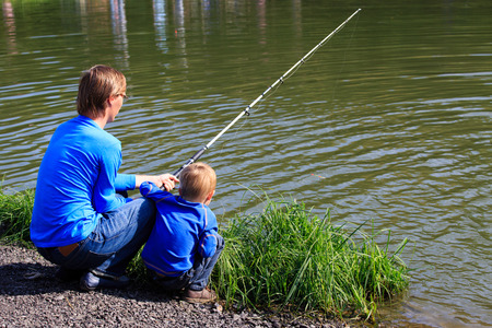 Father and son fishing on the lake in summerの写真素材