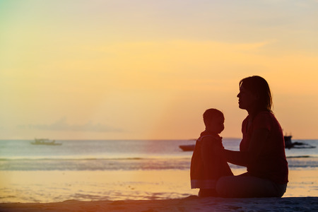 mother and little daughter on sunset tropical beachの写真素材