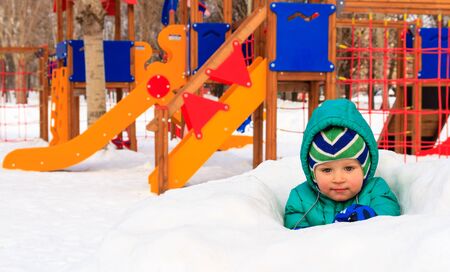 little boy having fun in winter playground outdoorsの写真素材