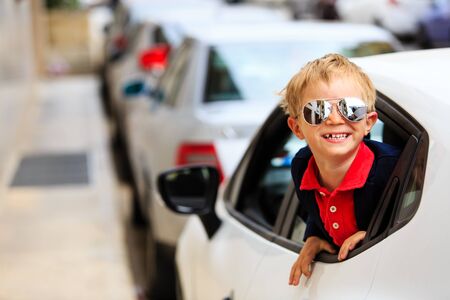 cute little boy travel by car in the cityの写真素材