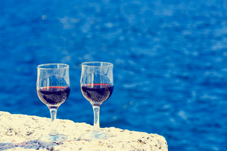 Two glasses of red wine against the sea, summer vacationの写真素材