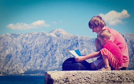father and son looking at map on mountains vacationの写真素材