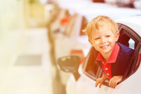 cute happy little boy travel by car in the city