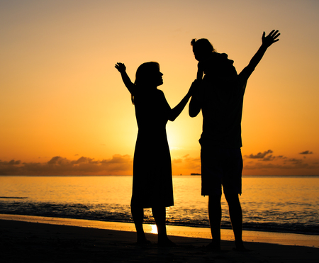 happy family with kid having fun on sunset tropical beachの写真素材