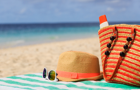 traw hat, bag, sun glasses and flip flops on a tropical beachの写真素材